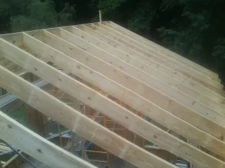 New roof rafters set over an addition before sheathing in Woolwine
