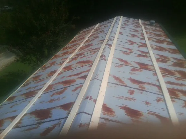 Rusted metal roof panels with new wood purlins before replacement — Storm Damage Roof Repair in Woolwine by Roofing Brothers