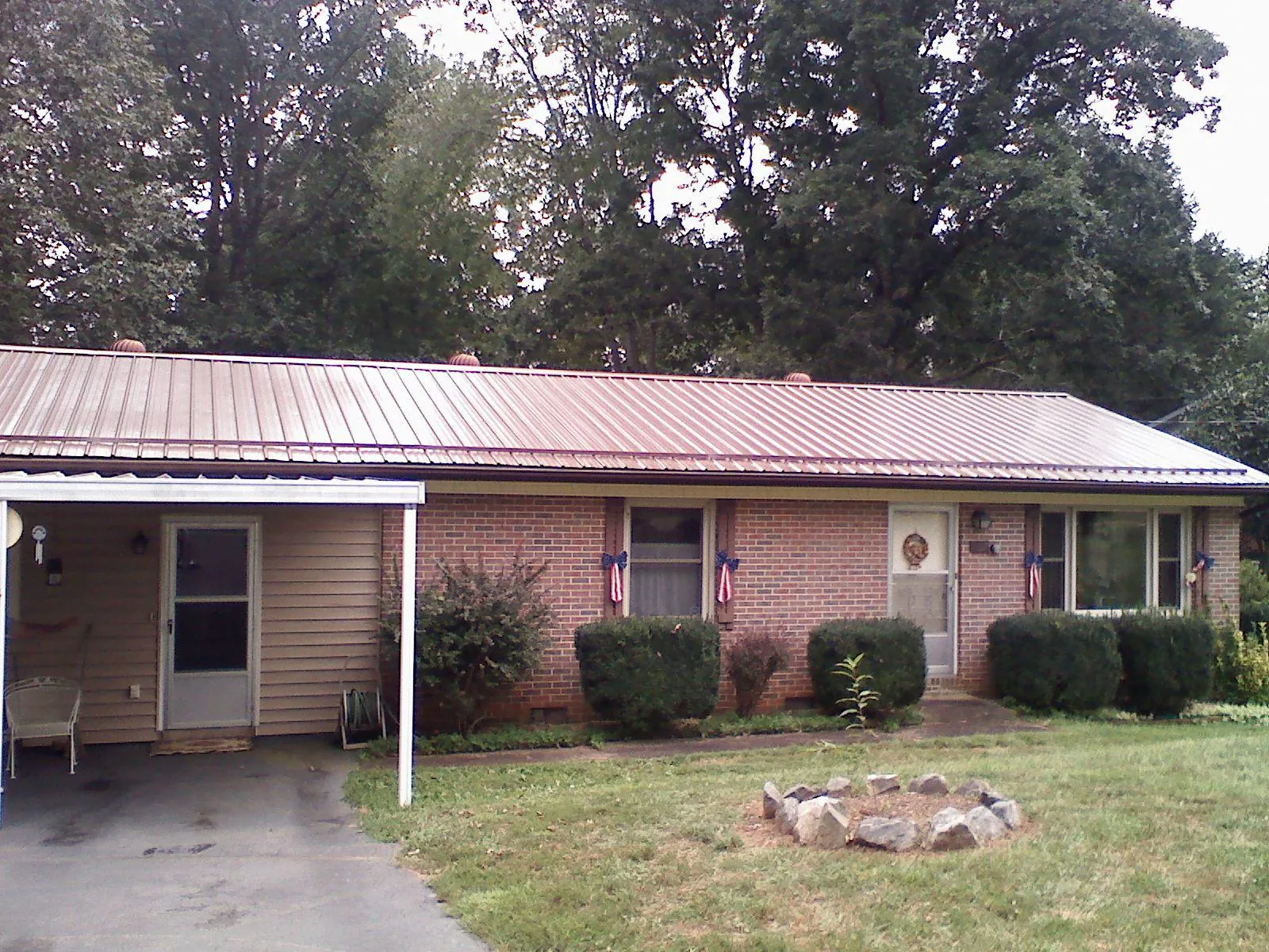 Bronze metal roof and carport on a brick ranch home — Roof Repair work by our crew in Woolwine